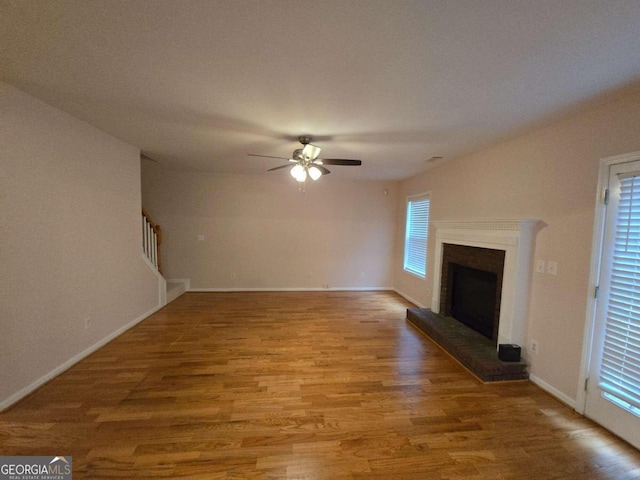 unfurnished living room with wood-type flooring and ceiling fan