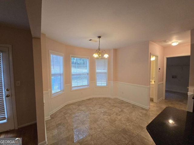 unfurnished dining area featuring an inviting chandelier