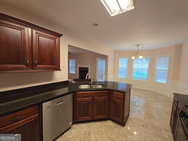 kitchen with sink, dishwasher, dark stone countertops, hanging light fixtures, and a notable chandelier