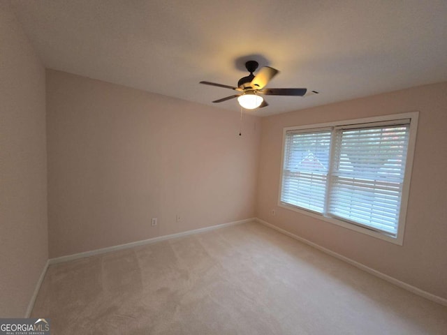 spare room with light colored carpet and ceiling fan