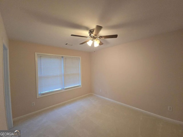 spare room with light colored carpet and ceiling fan