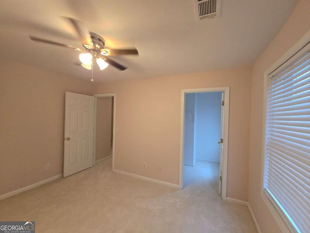 unfurnished bedroom featuring light colored carpet and ceiling fan