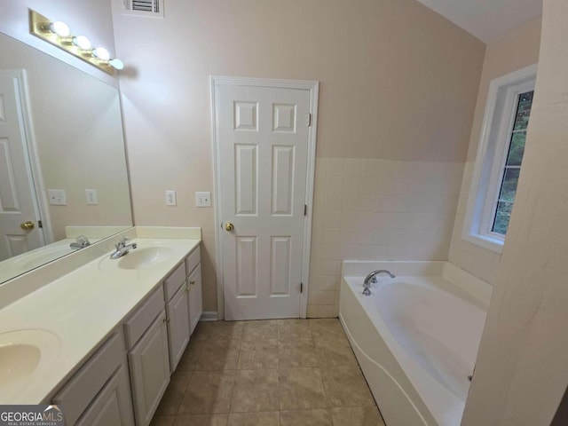 bathroom featuring vanity, tile patterned floors, and a tub to relax in