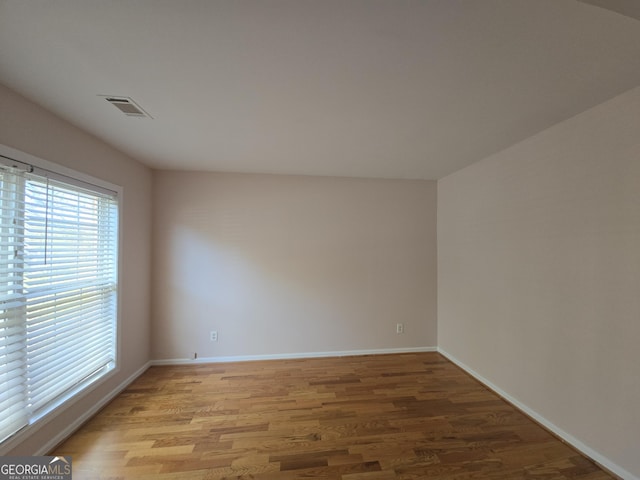 unfurnished room with hardwood / wood-style flooring