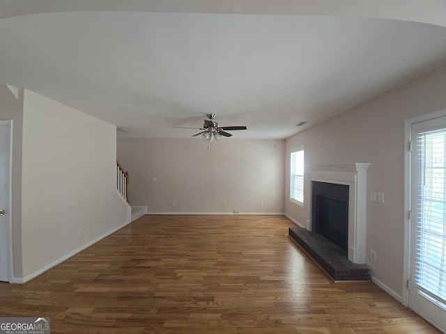 unfurnished living room with wood-type flooring and ceiling fan