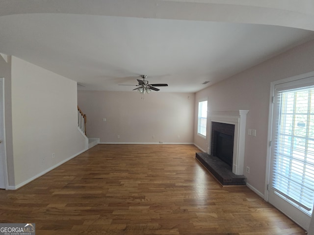 unfurnished living room with dark wood-type flooring and ceiling fan