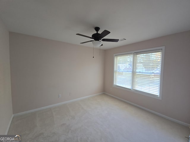 carpeted spare room featuring ceiling fan