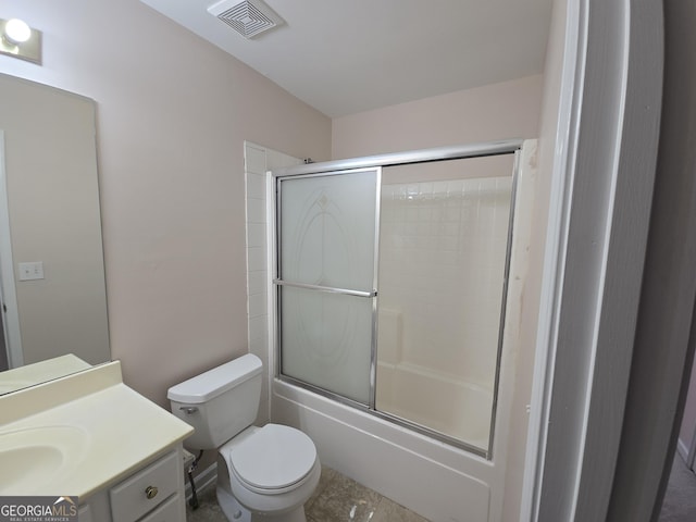 full bathroom with vanity, bath / shower combo with glass door, and toilet