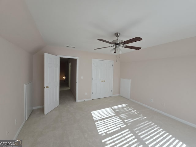 unfurnished bedroom with vaulted ceiling, light carpet, ceiling fan, and a closet