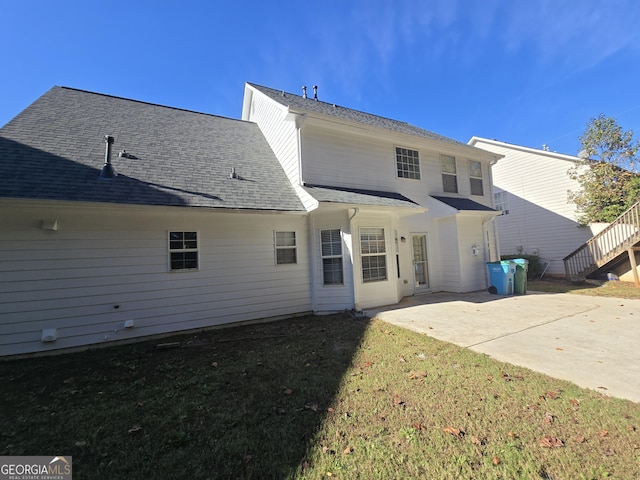 rear view of property with a lawn and a patio