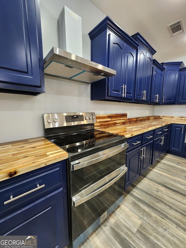 kitchen with wall chimney exhaust hood, wood counters, double oven range, and blue cabinets