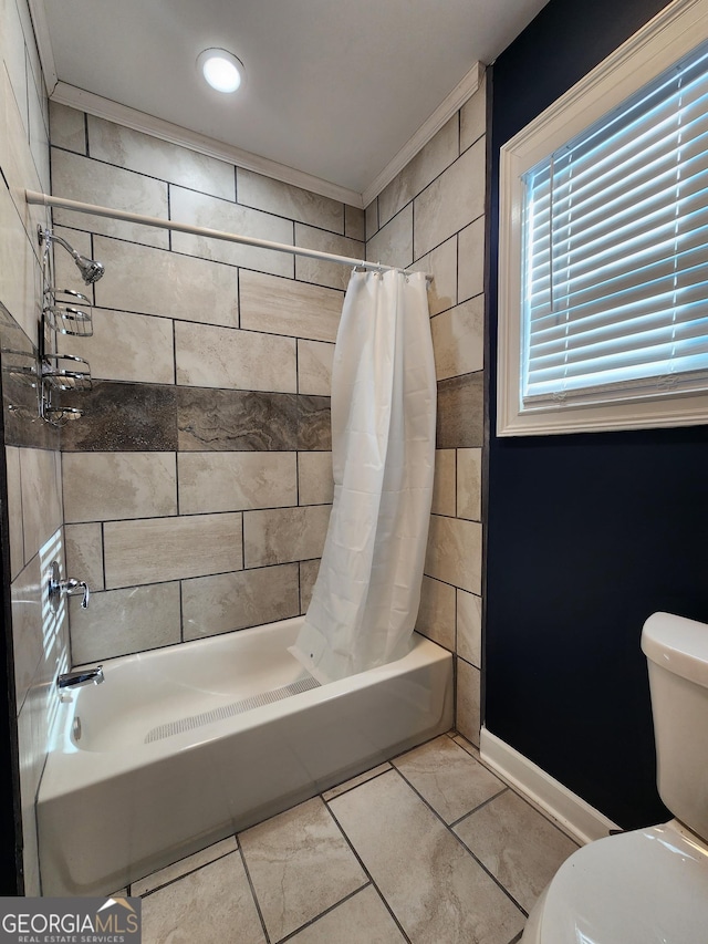 bathroom featuring toilet, ornamental molding, and shower / bath combo with shower curtain