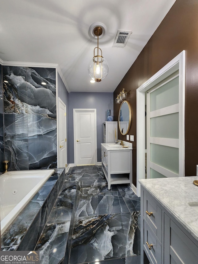 bathroom featuring tiled tub and vanity