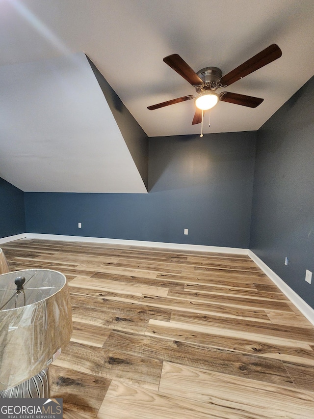 additional living space with hardwood / wood-style flooring and ceiling fan