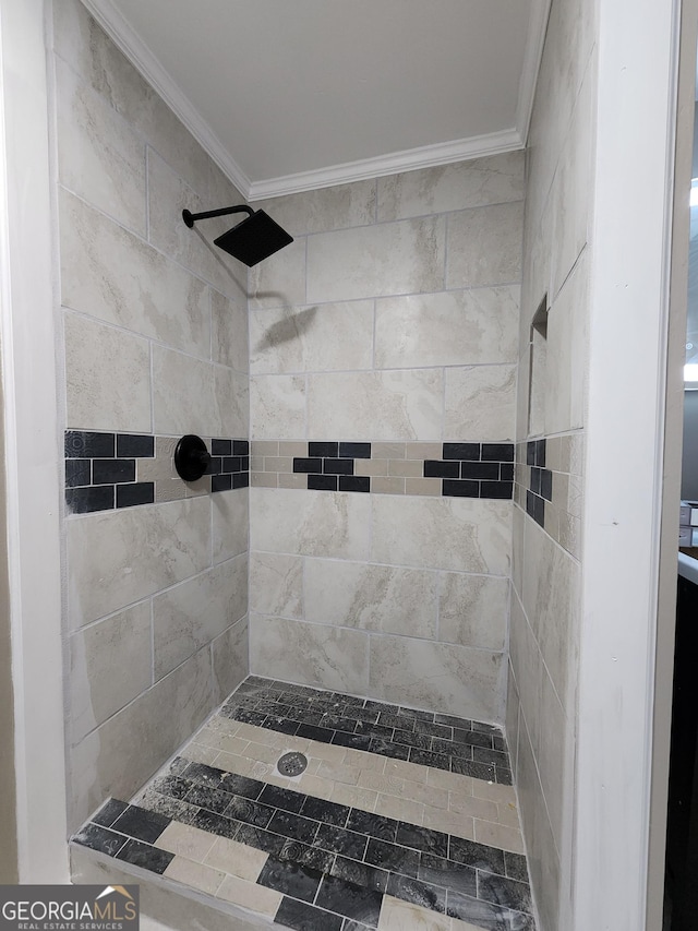 bathroom with crown molding and tiled shower