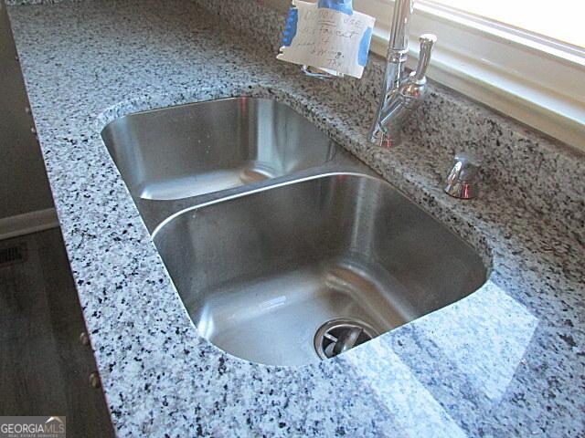 interior details with light stone countertops and sink