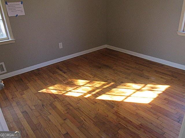 unfurnished room with dark hardwood / wood-style floors