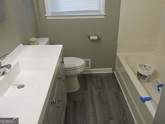 bathroom with wood-type flooring, toilet, and vanity