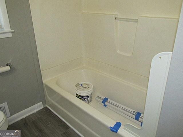 bathroom with hardwood / wood-style flooring and toilet