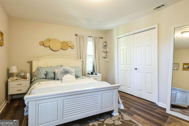 bedroom with dark hardwood / wood-style floors and a closet