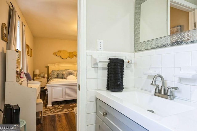 bathroom featuring vanity, backsplash, wood-type flooring, and tile walls