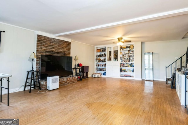 living room featuring hardwood / wood-style flooring, built in features, and ceiling fan