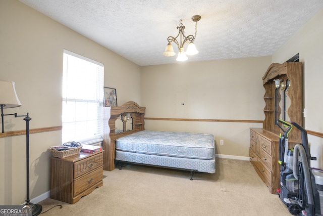 carpeted bedroom with a notable chandelier and a textured ceiling