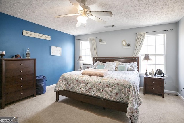 carpeted bedroom with a textured ceiling and ceiling fan