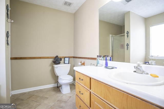 bathroom with vanity, toilet, a textured ceiling, and walk in shower