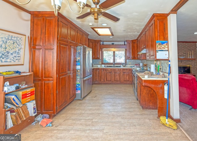 kitchen with stainless steel appliances, sink, ceiling fan, and decorative backsplash