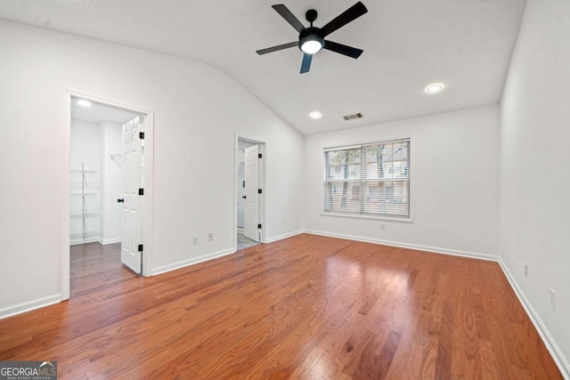 spare room with wood-type flooring, vaulted ceiling, and ceiling fan