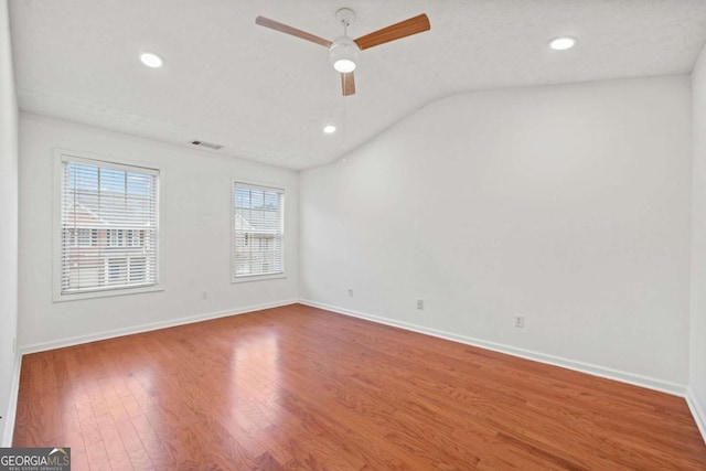 unfurnished room featuring lofted ceiling, hardwood / wood-style floors, and ceiling fan