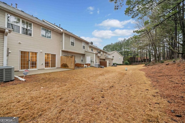 back of property with central AC and a patio area