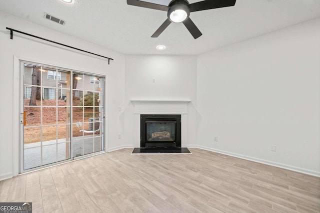 unfurnished living room with ceiling fan and light wood-type flooring