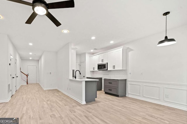 kitchen featuring pendant lighting, gray cabinets, ceiling fan, white cabinetry, and light hardwood / wood-style floors