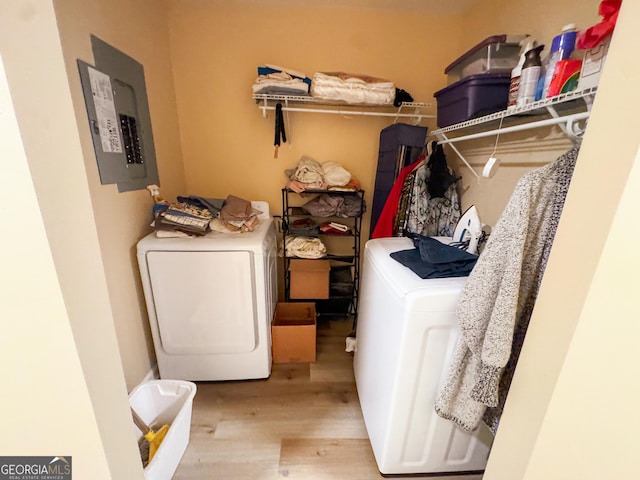 washroom with washer / clothes dryer, electric panel, and light hardwood / wood-style flooring