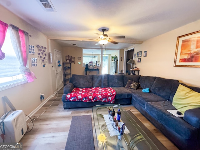 living room featuring ceiling fan, a wall mounted air conditioner, and light hardwood / wood-style floors