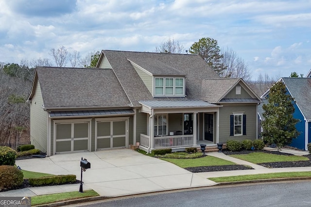 view of front facade featuring a shingled roof, concrete driveway, metal roof, an attached garage, and covered porch