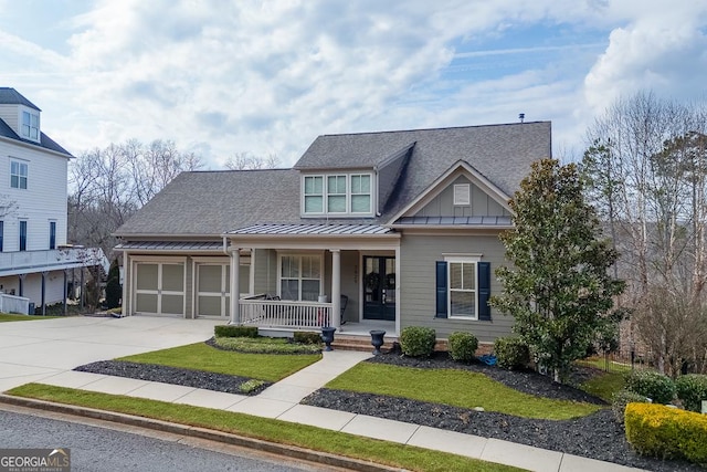 view of front of home with a porch, concrete driveway, roof with shingles, board and batten siding, and a standing seam roof