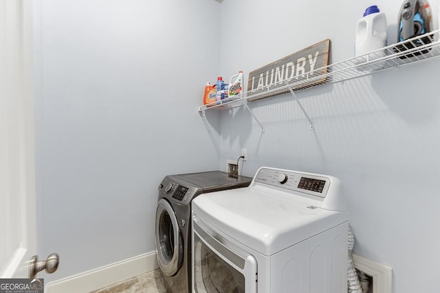 laundry room featuring laundry area, washer and clothes dryer, and baseboards