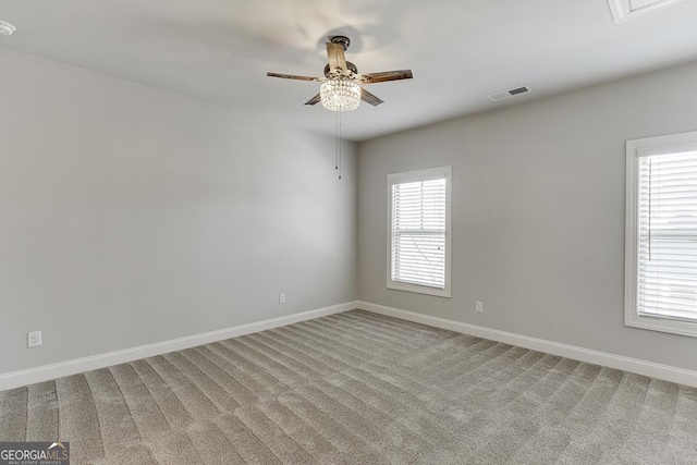 empty room featuring visible vents, plenty of natural light, and light carpet