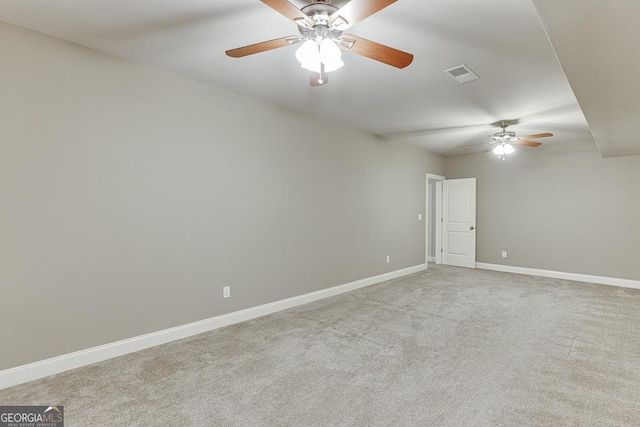 carpeted spare room with a ceiling fan, visible vents, and baseboards