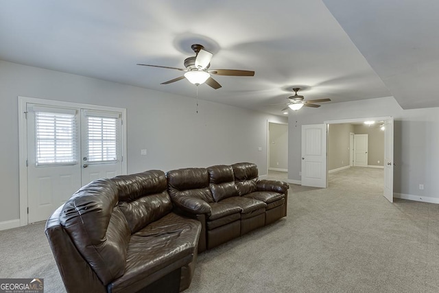 living room featuring light carpet, ceiling fan, and baseboards