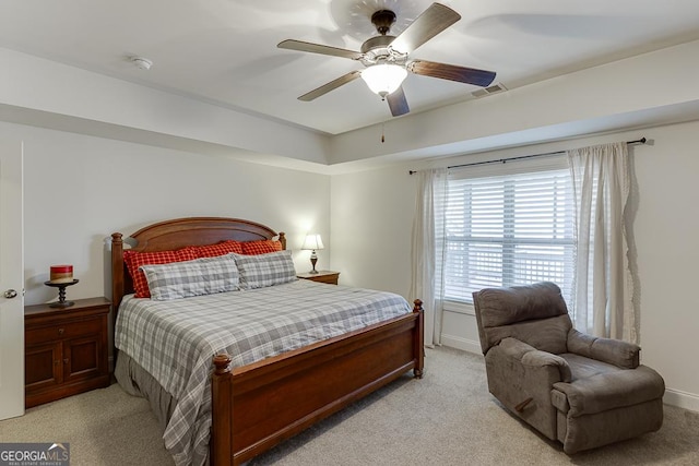 carpeted bedroom featuring a ceiling fan, visible vents, and baseboards