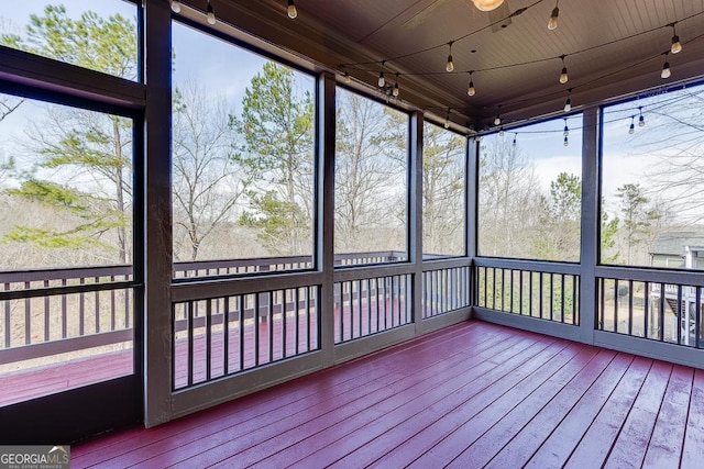 unfurnished sunroom featuring plenty of natural light and track lighting