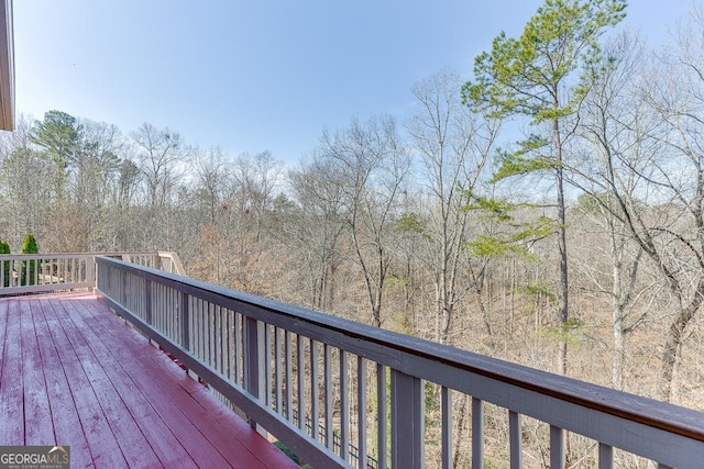 wooden terrace featuring a view of trees