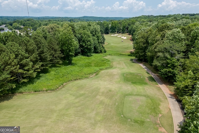 drone / aerial view featuring golf course view and a wooded view