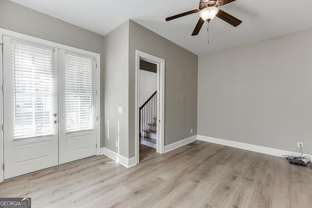 entrance foyer featuring stairs, a ceiling fan, light wood-style flooring, and baseboards