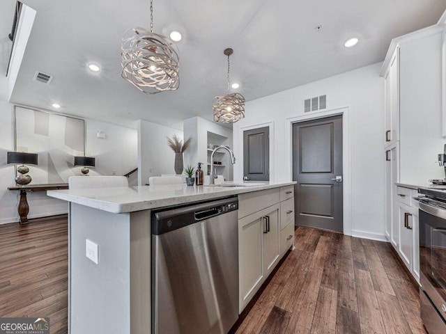 kitchen with pendant lighting, an island with sink, white cabinets, and appliances with stainless steel finishes