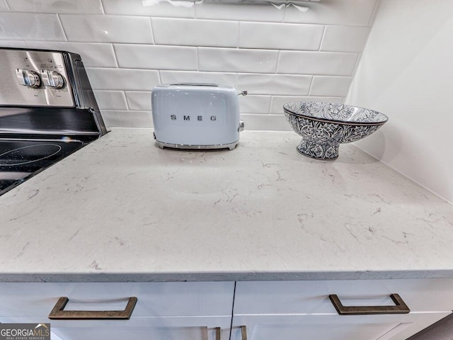 room details featuring tasteful backsplash and stainless steel range with electric stovetop